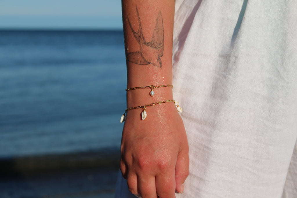 18K gold-plated waterproof tarnish-free paperclip chain bracelets, one with a single pearl, one with 3 mini seashells, handmade and woman owned by CHRMD.